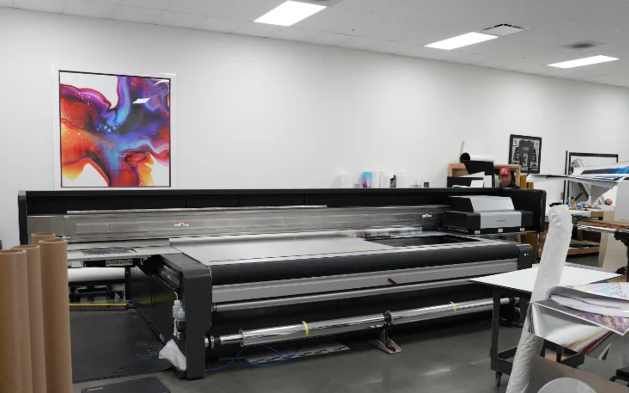 SwissQ Nyala flatbed UV printer, sheet loaded, lit and in focus